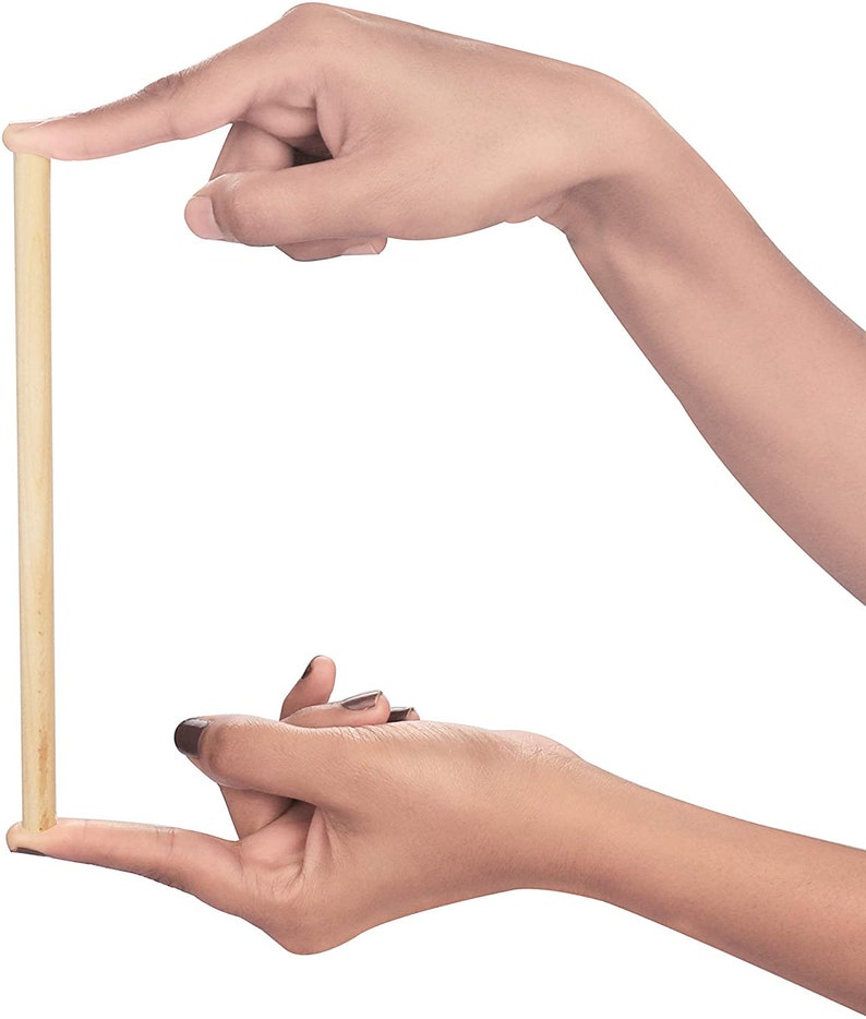 Puede incluir: Primer plano de una varilla de madera sostenida entre dos manos. La varilla es de color marr&oacute;n claro y parece ser lisa.