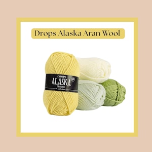 May include: A collection of Drops Alaska Aran Wool yarn in various colors. The image features a skein of yellow yarn with a black label, alongside skeins of cream, light green, and green yarn. The text "Drops Alaska Aran Wool" is displayed at the top.