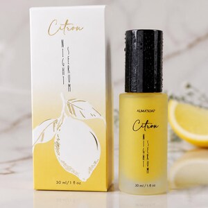 May include: A yellow glass bottle of Citron Night Serum with a black cap, next to a matching box. The box and bottle feature the text "Citron Night Serum" and a lemon illustration. A lemon slice is in the background. The bottle contains 1 fl oz.