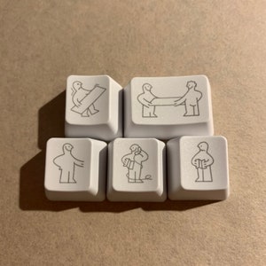 May include: Set of six white keycaps with different illustrations of people in various activities. The keycaps are designed to be used on a mechanical keyboard.