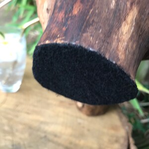 May include: A dark brown wooden base with a black felt bottom. The base is designed to hold a decorative object.