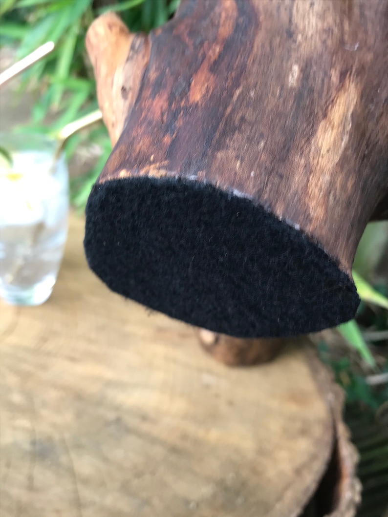 May include: A dark brown wooden base with a black felt bottom. The base is designed to hold a decorative object.