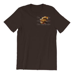 May include: A dark brown t-shirt featuring a UPS logo design on the front. The logo is in shades of brown, gold, and black. The text "Chic And Rooster" is printed in a cursive font.