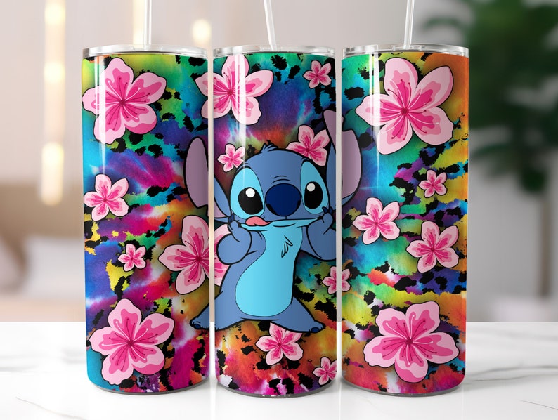 May include: Three stainless steel tumblers with a colourful tie-dye and leopard print design. The centre tumbler features a blue cartoon character with a pink tongue and four fingers. The character is Stitch from the Disney movie Lilo & Stitch.