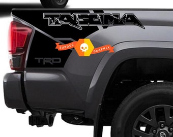 May include: Black and grey truck bed decals with the word "TACOMA" in white lettering and a skull graphic. The decals also include the text "SUPDEC GRAPHIX" and "TRD".