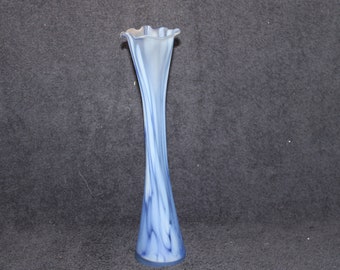 May include: A tall, slender blue and white glass vase with a flared opening. The vase has a swirling, marbled pattern.