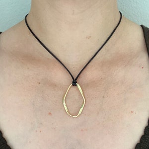 Adjustable black cord necklace with gold wavy hammered open oval pendant