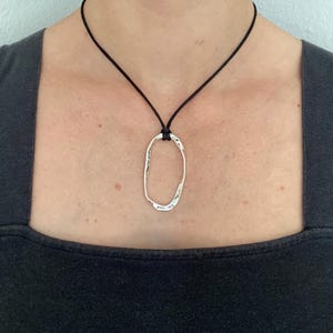 Adjustable black cord necklace with silver wavy hammered open oval pendant