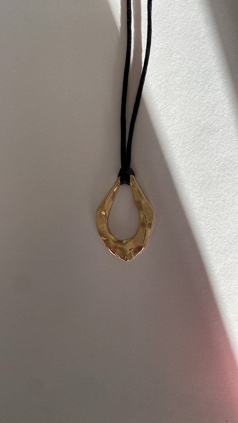 Adjustable black cord necklace with gold wavy hammered open oval water drop pendant image 3