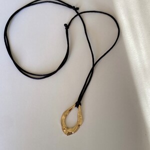 Adjustable black cord necklace with gold wavy hammered open oval water drop pendant image 4