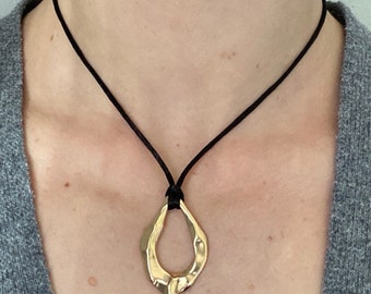 Adjustable black cord necklace with gold wavy hammered open oval water drop pendant