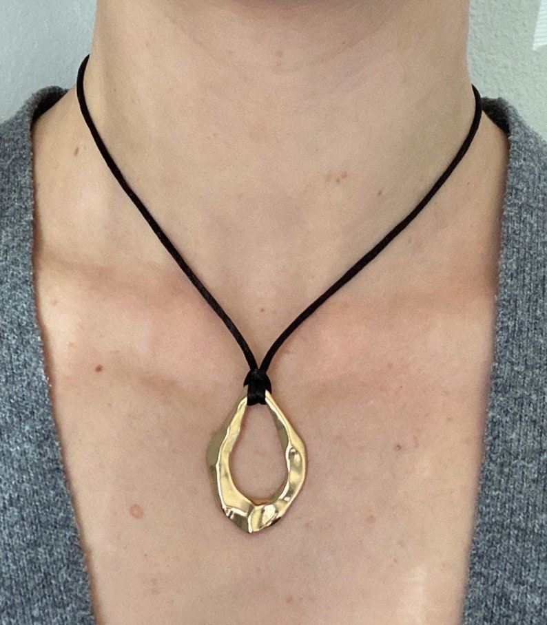 Adjustable black cord necklace with gold wavy hammered open oval water drop pendant image 1