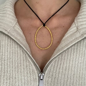 Adjustable black cord necklace with gold wavy hammered open teardrop pendant