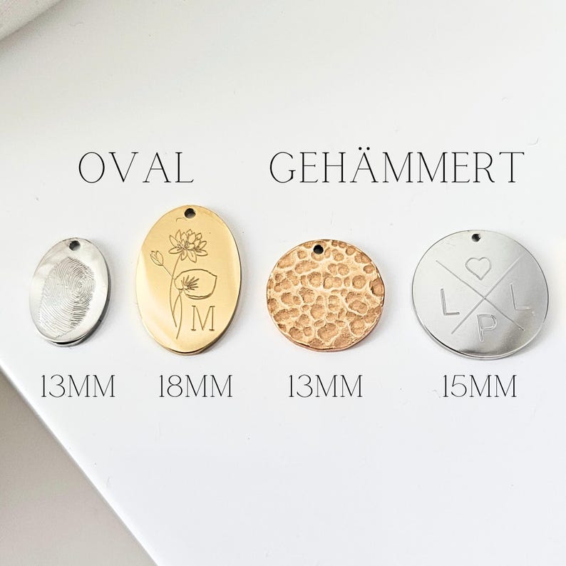 May include: Four different metal pendant charms, two oval and two round. The oval charms are 18 mm and 13 mm. The round charms are 13 mm and 15 mm. The charms are engraved with different designs, including a flower, a fingerprint, a hammered texture, and a heart with initials.