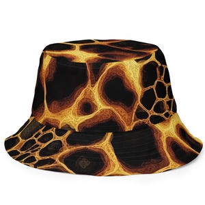 May include: A bucket hat featuring a repeating pattern of black and golden-yellow organic shapes that resemble flowing lava or a cracked surface. The design covers the entire crown and the downward-sloping brim of the hat in a continuous print.