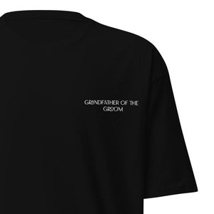 May include: Black t-shirt with the text "Grandfather of the Groom" in white.