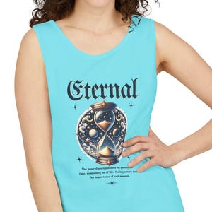 May include: A light blue tank top with the word "Eternal" in a stylized font. The tank top features an hourglass design with celestial elements. Below the hourglass is a line of text. The tank top is sleeveless.