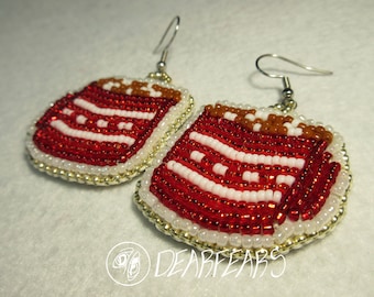May include: A pair of red, white, and brown beaded earrings shaped like a layered cake. The earrings are made with small seed beads and have a silver hook.