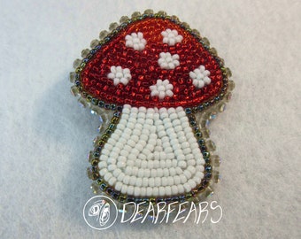 May include: A beaded mushroom with a red cap and white spots, and a white stem with a beaded border.