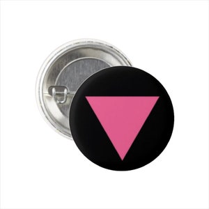 Pode incluir: Um botão preto com um triângulo rosa no centro. O botão é um símbolo de orgulho e aceitação.
