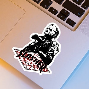 May include: A black and white sticker featuring a horror movie character holding a weapon. The sticker has the word "SLASHER" in a diamond shape with red blood splatter accents. The sticker is on a laptop.