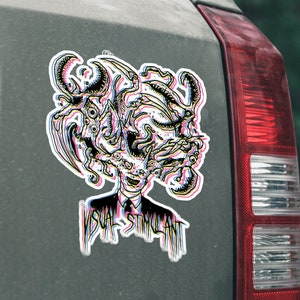 May include: A black and white sticker with a colorful, psychedelic design of a creature with multiple eyes and tentacles. The sticker is on the back of a gray car and says "Visual Stimulant".