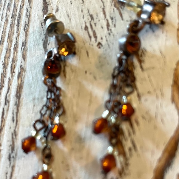 Pierced small round clear crystal bead with dual dangles of dark amber/garnet colored beaded earrings