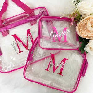 May include: Three clear plastic zippered bags with pink trim. Each bag has the name "Melissa" printed in silver with a large pink "M" in the center.