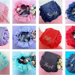 May include: Twelve different drawstring makeup bags in various colors, each with a personalized name embroidered on the front. The bags are filled with makeup and other toiletries.