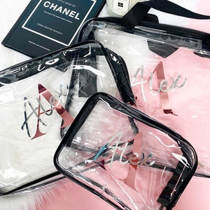May include: Three clear plastic zippered pouches with black trim and rose gold lettering. The pouches are labeled "Alex" in a cursive font.