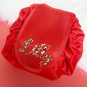 May include: Red drawstring makeup bag with a leopard print name "Lilly" on the front.