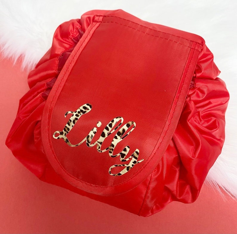 May include: Red drawstring makeup bag with a leopard print name "Lilly" on the front.