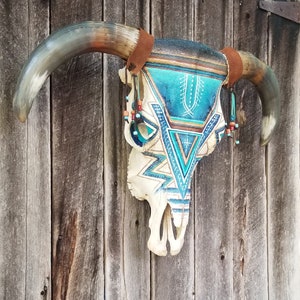 SOLD. This item has been sold.      Beautiful very large symmetrical hand painted real bull skull.