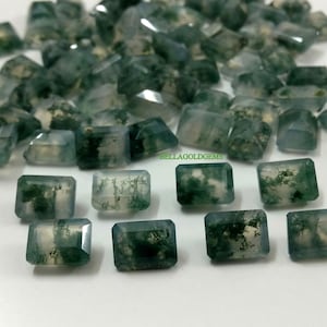 Può includere: Una collezione di pietre preziose di agata muschiata tagliate a smeraldo rettangolare. Le pietre sono un mix di verde e bianco con un aspetto traslucido.