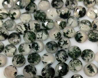 May include: A collection of moss agate cabochons, featuring a variety of green and white patterns. The cabochons are smooth and polished, with a rounded shape.