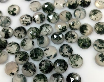 May include: A collection of round, faceted, moss agate cabochons. The stones are translucent and have a white base with green moss-like inclusions.
