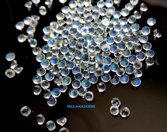 May include: A collection of faceted, round gemstones with a clear, iridescent appearance. The gems display flashes of blue, green, and yellow, scattered across a dark surface. The image is well-lit, showcasing the gems' clarity and cut.
