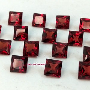 May include: A collection of 18 red square-shaped gemstones. The gemstones are arranged in rows on a white surface. The text "BELLAGOLDGEMS" is visible in the lower right corner of the image.