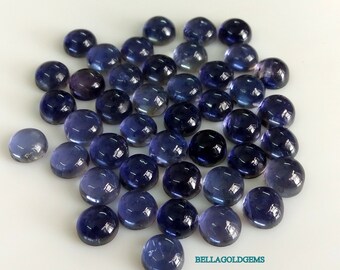Puede incluir: Una colección de 40 cabujones redondos de piedra preciosa azul-púrpura. Los cabujones son lisos y pulidos, con un ligero brillo.