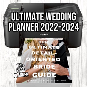 May include: A black Canon printer with a wedding planner magazine on top. The magazine cover features a couple toasting with champagne glasses and the text "The Ultimate Detail-Oriented Bride Guide".