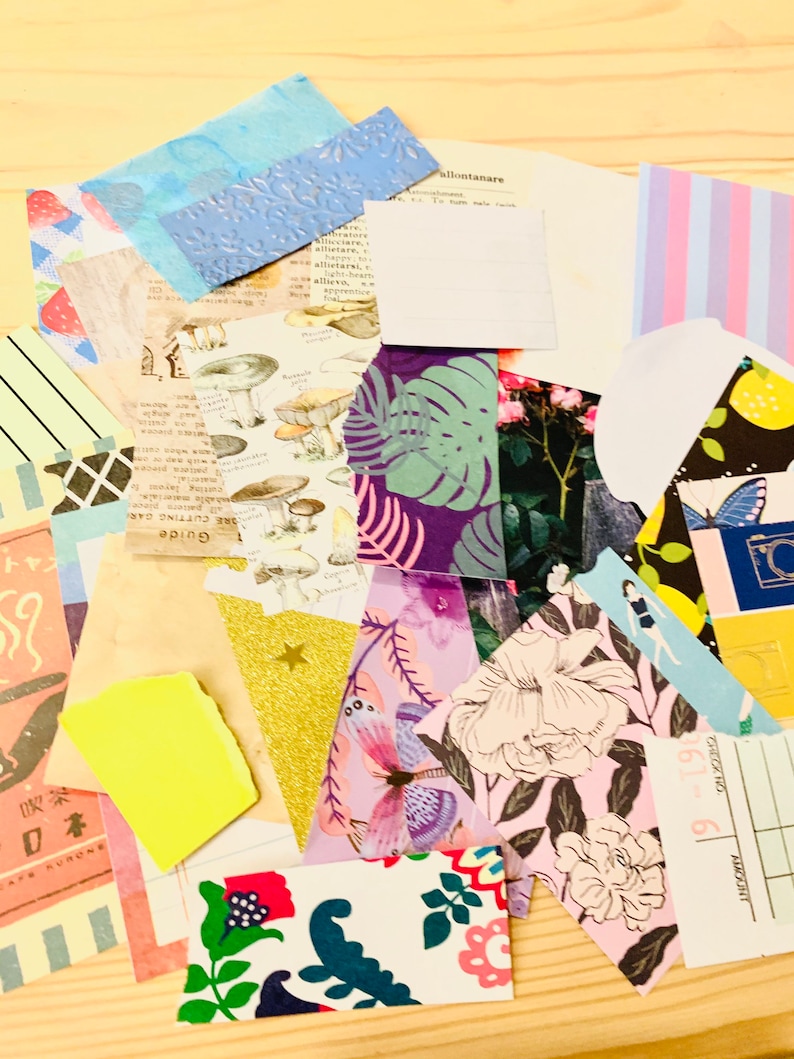 Peut inclure: Un ensemble de papiers de diff&eacute;rentes couleurs avec des motifs et des designs vari&eacute;s, notamment des fleurs, des papillons, des champignons et des formes g&eacute;om&eacute;triques. Les papiers sont dispos&eacute;s de mani&egrave;re al&eacute;atoire sur une surface en bois.