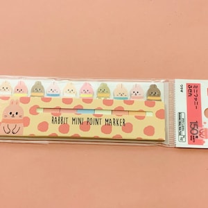 Könnte beinhalten: Eine Packung mit 150 Mini-Punktmarkern mit einem Hasendesign. Die Marker sind in verschiedenen Farben erhältlich und haben jeweils ein süßes Hasengesicht. Die Packung ist mit "Rabbit Mini Point Marker" beschriftet.