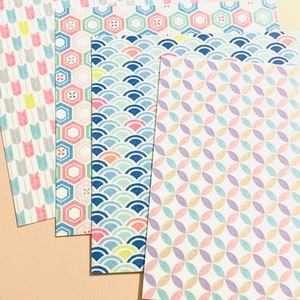 May include: A selection of patterned paper sheets featuring diverse designs. The patterns include arrows, hexagons, waves, and overlapping circles, in pastel shades such as pink, blue, yellow, and purple. The paper has a textured finish.