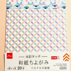 May include: A pack of Japanese origami paper with a pastel geometric pattern. The paper features a repeating design of overlapping circles in shades of pink, purple, yellow, and blue. The package includes Japanese text and measures 15cm x 15cm.