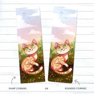 May include: A bookmark featuring a cartoon cat with orange and white fur, green eyes, and a pink nose. The cat is sitting in a field of green grass with yellow flowers. The background is a soft pink and blue sky with white clouds. The bookmark is available with either sharp or rounded corners.
