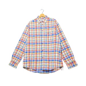 Può includere: Una camicia a maniche lunghe con bottoni e un motivo a quadri colorati in tonalità di blu, rosso, giallo e bianco.