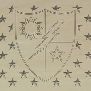 Puede incluir: Placa de madera con un diseño de escudo que incluye un sol, un rayo y una estrella, rodeado de estrellas grises. El diseño está grabado en la madera, lo que le da un aspecto rústico y patriótico. La madera es de color claro.