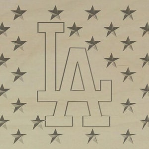 May include: A wooden sign with a white outline of the letters "LA" on a background of gray stars.