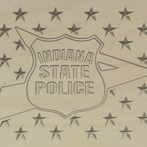 May include: A wooden plaque with a star pattern background and a raised, gray shield with the text "INDIANA STATE POLICE" in white.