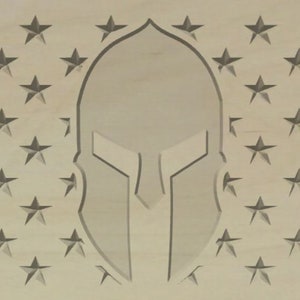 Puede incluir: Una placa de madera con un diseño de casco espartano en el centro, rodeada por un borde de estrellas.